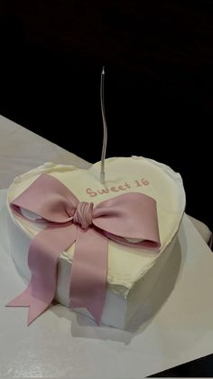 a heart shaped cake with a pink bow on it's top and the words sweet 16