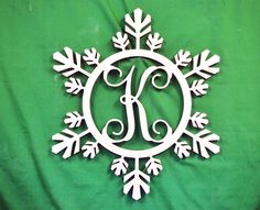 a snowflake with the monogrammed letter j on it is shown in front of a green background