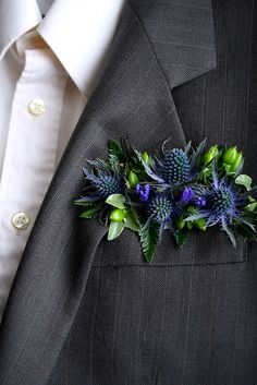 a boutonniere with blue flowers is placed on a man's suit