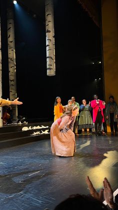 a group of people standing on top of a stage with one person kneeling down in front of the other