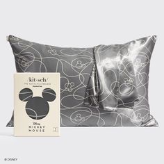 the mickey mouse pillow is next to a book