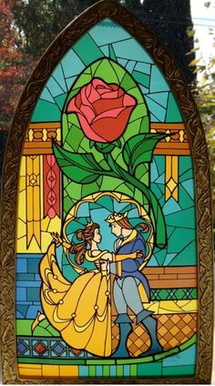 a stained glass window with an image of the beauty and the beast holding a rose