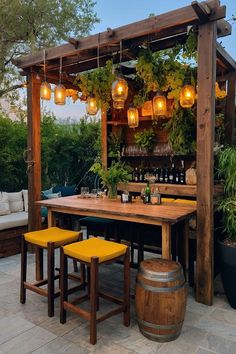 an outdoor bar with yellow stools and potted plants on the outside patio area