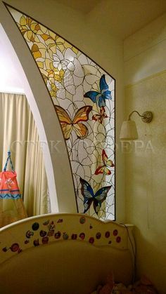 a stained glass window in the corner of a room with a crib and bed