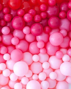 pink and white balloons are arranged in a pattern on the wall, as seen from above