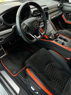 the interior of a sports car with orange stitching and black leather trimmings