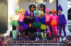 a group of children dressed in costumes posing for a photo on the front steps of a house