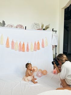 a woman taking pictures of a baby with balloons