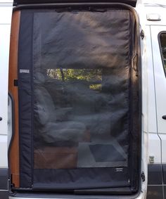 the back door of a white van with black tarp on it's side