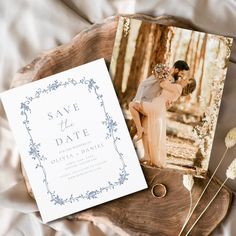 a wedding save the date card and photo on a wood slice with flowers in it