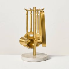 there is a clock made out of brass parts on a marble base with gold handles