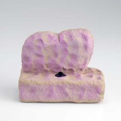 a purple and white rock with a hole in it