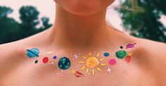 a woman with painted sun and planets on her chest