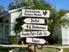 a street sign in front of a house with many signs pointing to different locations on it