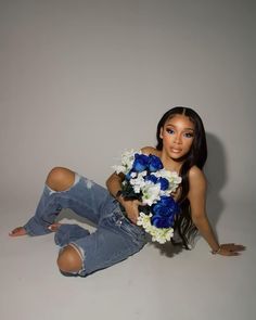 a barbie doll is holding flowers and posing for the camera with her legs spread out