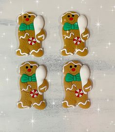 four decorated gingerbread cookies sitting on top of a table