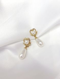 Vintage Inspired Earrings from the 1950s & 1960s. This beautiful Vintage Faux Pearl Classic Heart-Wing Drop Earrings are plated in Champagne Gold tone metal leading to a Classic style elongated white faux pearl tear drop. Earrings will be provided with Gold plated Butterfly backs. Items will be wrapped in a beautiful gift box.  Go Social : FOLLOW US ON INSTAGRAM : @RAQUEL.VINTAGE Retro Yellow Gold Formal Earrings, Gold Heart Shaped Clip-on Earrings For Wedding, Vintage Single Earring For Formal Occasions, Vintage Teardrop Clip-on Earrings As Gift, Classic Gold Heart Earrings For Formal Occasions, Gold Heart-shaped Clip-on Earrings For Wedding, Gold Elegant Heart Earrings, Heart-shaped Clip-on Earrings For Formal Occasions, Elegant Gold Clip-on Heart Earrings