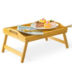 a wooden tray with cake on it and two forks in front of the tray,