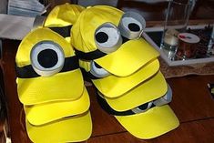 two pairs of yellow shoes with googly eyes are on a table next to a bottle