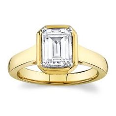 a yellow gold ring with an emerald cut diamond