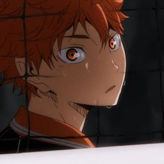 an anime character with red hair and orange eyes stares at something in the distance behind him