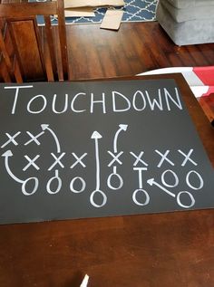 a chalkboard with the words touch down and arrows drawn on it in front of a couch