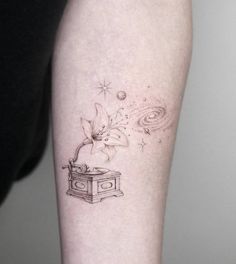 a tattoo on the arm of a woman with a cat in a box and stars