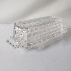 a clear glass container sitting on top of a white tableclothed surface with an object in the middle