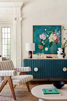 a living room filled with furniture and a painting on the wall