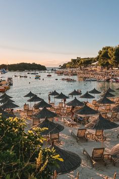 many umbrellas are set up on the beach for people to sunbathe in