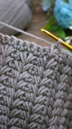 the yarn is being worked on with a yellow needle