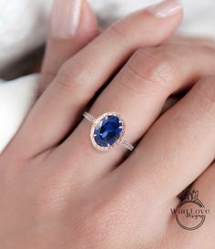 a woman's hand with a ring on her finger and a blue stone in the middle