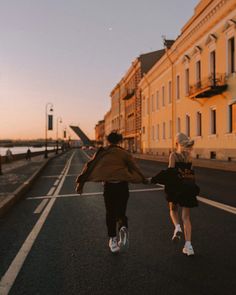 two people walking down the street holding hands