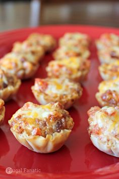 mini pizzas with cheese and meat are on a red plate, ready to be eaten