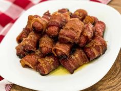 a white plate topped with bacon on top of a red and white checkered table cloth