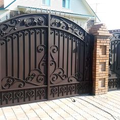 an iron gate in front of a brick house