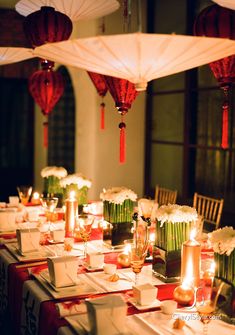 a long table is set with candles and napkins for an elegant chinese wedding reception