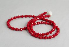 Opaque with sparkle, these red crystal beads are easy to wear and striking! The crystal rondelle beads are small to medium size with plenty of facets to reflect the light. Slip it on over your head or use the beautiful rhinestone magnetic clasp. It is 30 inches long (76 cm) and lightweight enough to layer with other necklaces. It is made with 4mmx6mm and 6mmx8mm beads. This necklace and all KBeadsIt jewelry ship fast and free with USPS first class domestic package service. The black, silver, and Red Single Strand Crystal Necklace With Round Beads, Red Crystal Necklace With Single Strand Round Beads, Red Crystal Round Bead Necklaces, Red Crystal Round Bead Necklace, Red Rondelle Single Strand Beaded Necklace, Red Rondelle Beaded Necklace, Single Strand, Red Faceted Rondelle Beaded Necklaces, Red Rondelle Beaded Necklace Single Strand, Red Crystal Necklace With Round Beads