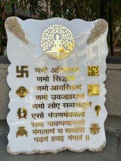 a white sign with gold lettering on it