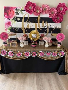 a table topped with pink flowers and decorations