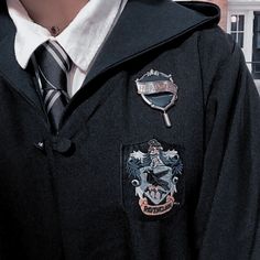 a man wearing a black jacket and tie with badges on it