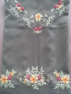 an embroidered fabric with flowers and leaves on it