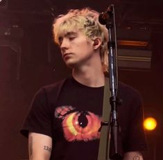 a young man with blonde hair is playing the guitar