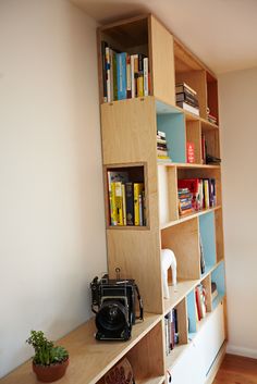 a bookshelf filled with lots of books next to a wall full of books