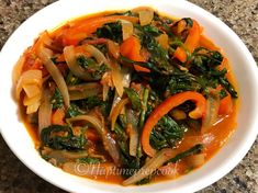 a white bowl filled with vegetables on top of a table