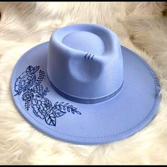 This Blue Western/ Boho Hat Features Florals On The Brim And A Feather Tucked To The Side Of The Blue Velvet Ribbon Hat Band. S/M Polyester Trendy Blue Hat With Curved Brim, Trendy Blue Hats For Festival, Trendy Blue Hat For Festival, Blue Fedora With Flat Brim, One Size Fits Most, Blue Adjustable Felt Hat With Short Brim, Blue Fedora Hat One Size Fits Most, Blue Fedora With Flat Brim, Blue Flat Brim Fedora One Size Fits Most, Blue Flat Brim Fedora One Size