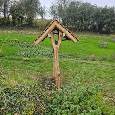 a wooden structure in the middle of a field