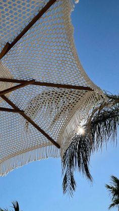 an open umbrella with palm trees and blue sky in the backgroung area