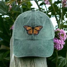 Monarch Butterfly embroidered on a pigment dyed cap in choice of color. Shown on forest   Colors may not look the same on all monitors Adams brand 100% garment-washed cotton twill 6-panel, unstructured, low-profile tuck-away back leather strap with antiqued brass buckle and grommet adjustable.  fits most men and women Cool-Crown™ mesh lining four rows of stitching on bill Garment washed, pigment dyed gives the cap a nice faded look Caps made in china-embroidery done in USA Spring Outdoor Snapback Dad Hat, Snapback Dad Hat For Outdoor Use In Spring, Spring Soft-washed Curved Bill Hats, Green Baseball Cap For Spring Outdoor Activities, Green Baseball Cap For Outdoor Spring Activities, Green Dad Hat For Outdoor Spring Activities, Spring Outdoor Dad Hat With Curved Brim, Spring Outdoor Washed Hat, Spring Outdoor Dad Hat With Visor