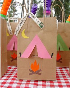 three paper bags with camping related items on them